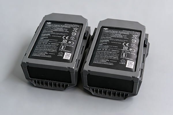 A swollen, puffy Li-Po battery next to a normal, flat one, highlighting the dangerous deformity