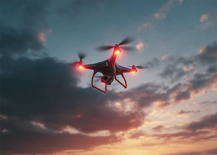 An animation showing two identical drones, one with no payload and one with a heavy payload, with their battery indicators depleting at different rates.