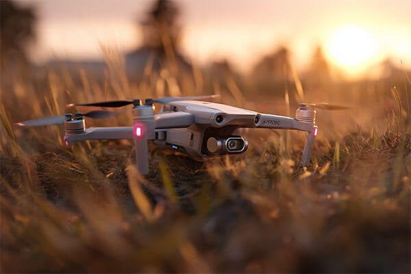 An animation showing two identical drones, one with no payload and one with a heavy payload, with their battery indicators depleting at different rates